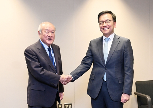Finance Minister Choi Sang-mok (R) and Japan's Finance Minister Shunichi Suzuki shake hands ahead of their meeting in Washington on April 16, 2024, in this photo provided by South Korea's finance ministry. (PHOTO NOT FOR SALE) (Yonhap)