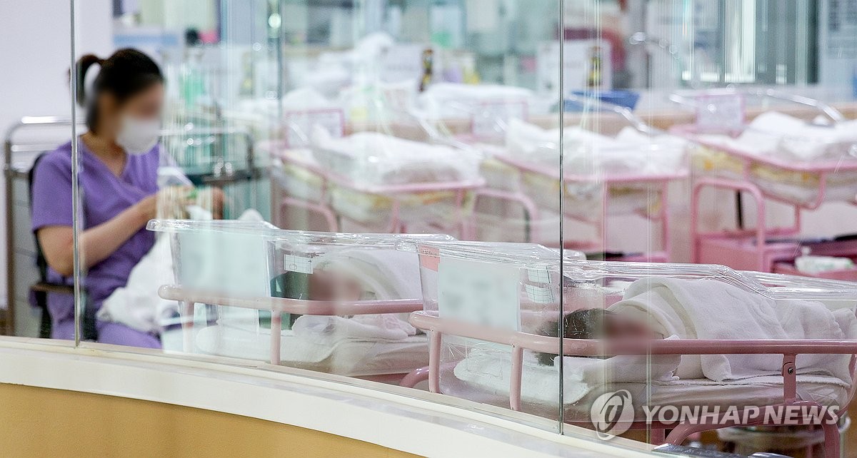 This file photo taken Feb. 28, 2024, shows an official taking care of a baby at a postnatal care center in Seoul. (Pool photo) (Yonhap)