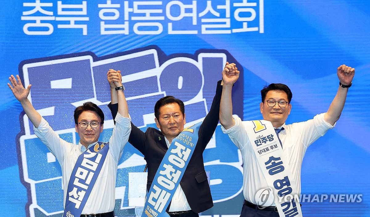 Candidates for the ruling Democratic Party's leadership race -- (from L to R) Kim Min-seok, Chung Cheong-rae and Song Young-gil -- hold their hands up together to greet the crowd at a joint speech for the preliminary elections for party leader and Supreme Council members at CJB Media Center in Cheongju, North Chungcheong Province, on Aug. 1, 2026. (Yonhap)