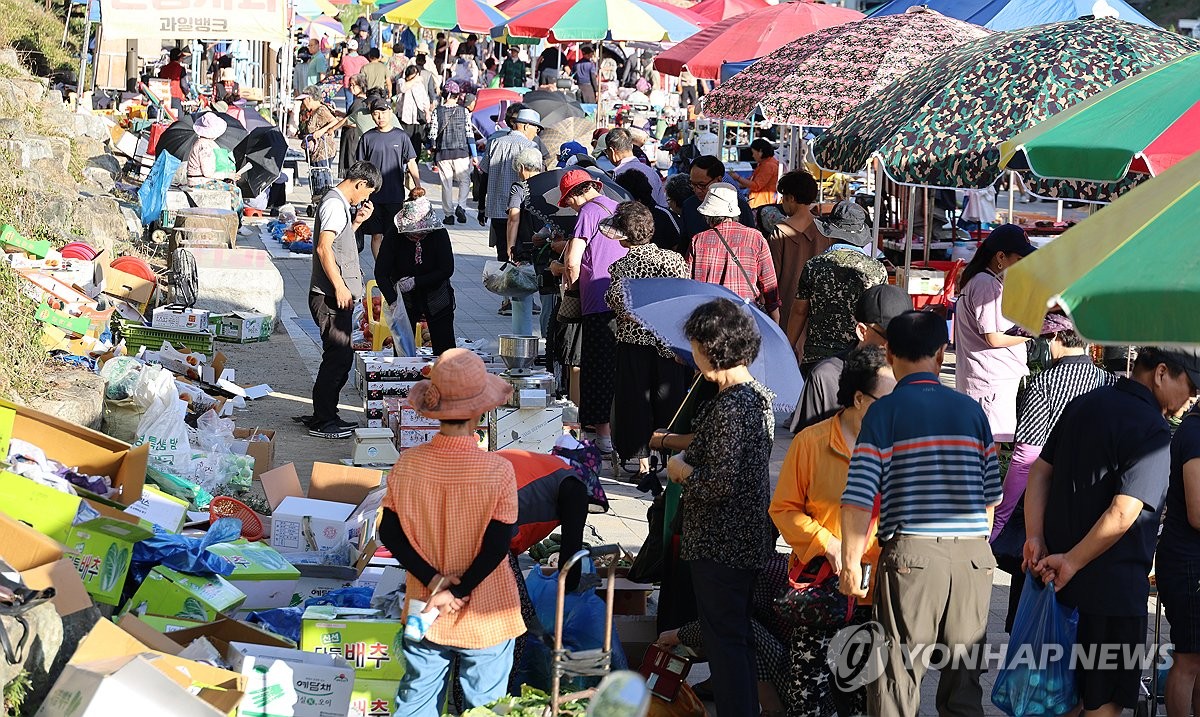People shop for vegetables, fish and other items at an early-morning market in Jeonju, North Jeolla Province, southwestern South Korea, on Aug. 13, 2026. The market, which opens for about five to six hours beginning at dawn every day, is popular as it has reasonable prices. (Yonhap) (END)