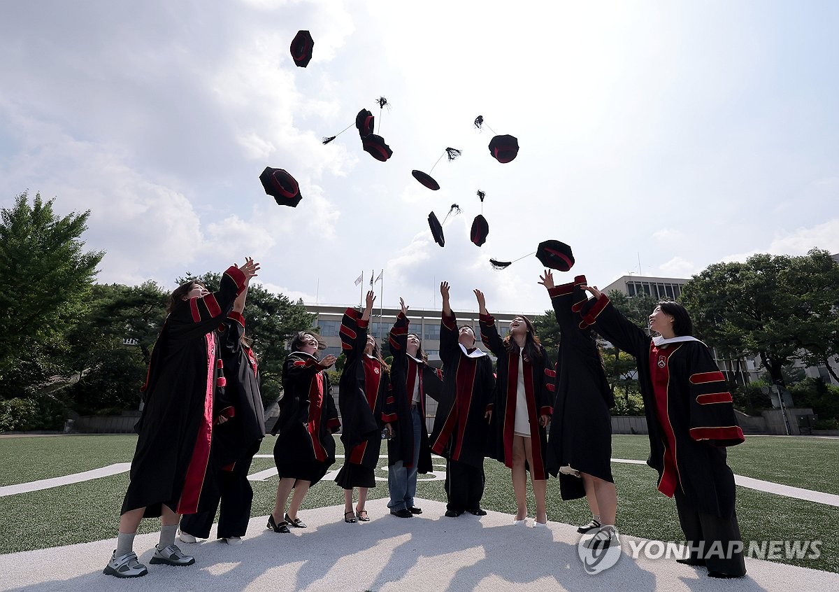 Graduates clad in borrowed gowns fling their graduation caps into the air after attending the second commencement ceremony of the 2026 academic year at Sogang University in Seoul on Aug. 18, 2026. (Yonhap) (END)