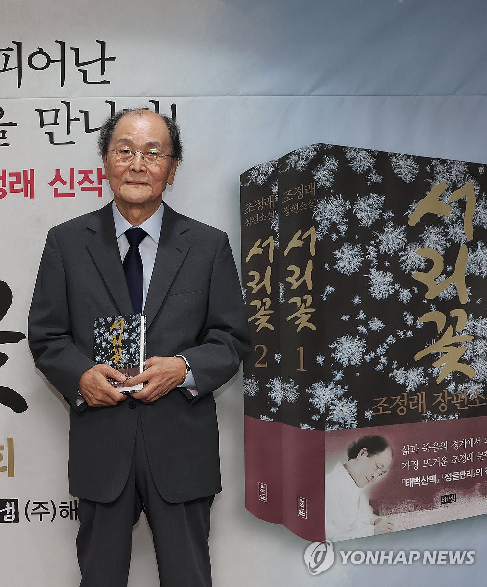 Renowned novelist Jo Jung-rae poses for a photo with a copy of his new novel, "Seorikkot" (Frost Flower), during a press conference in Seoul on Aug. 24, 2026, to mark the publication of the novel. (Yonhap) (END)