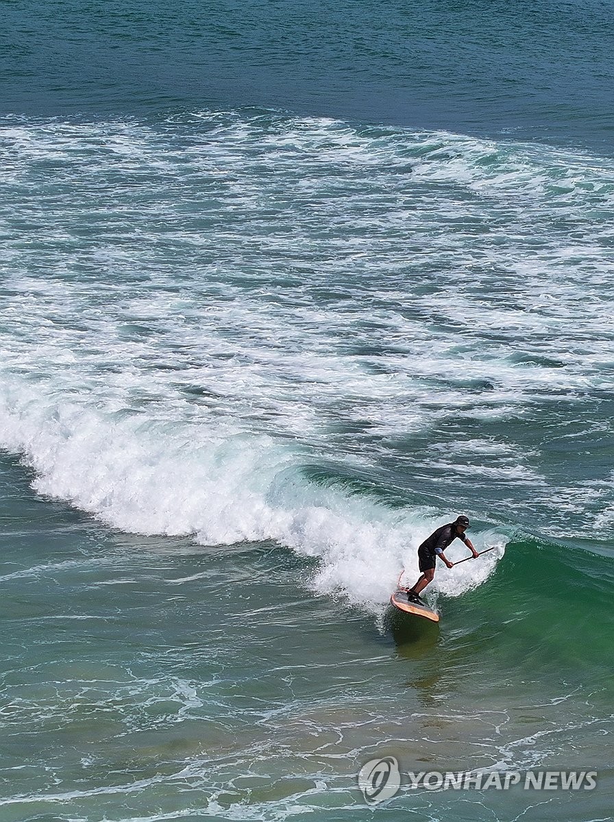 A surfer rides waves off a beach in the town of Yangyang, Gangwon Province, northeastern South Korea, on Aug. 4, 2026. (Yonhap) (END)