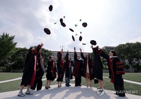 Graduates clad in borrowed gowns fling their graduation caps into the air after attending the second commencement ceremony of the 2026 academic year at Sogang University in Seoul on Aug. 18, 2026. (Yonhap) (END)