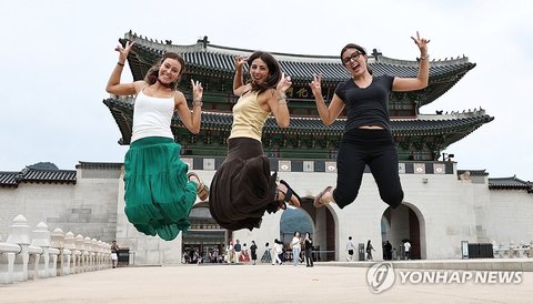 Spanish tourists jump in the air for a photo in front of Gwanghwamun in central Seoul on Aug. 30, 2026. (Yonhap) (END)