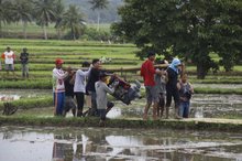 Farmers carry a water pump to a rice field in an effort to maintain irrigation water availability, maintain rice productivity, and mitigate the impact of drought during the dry season.
