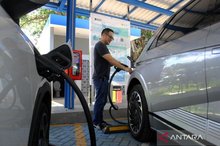 An electric vehicle owner charges his car 