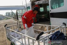 An officer loads sodium chloride (NaCl) seeding agents into a Cessna 208B Grand Caravan EX aircraft