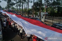 Participants unfurl a red-and-white cloth during the Red-and-White Parade