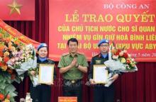 Deputy Minister of Public Security Sen. Lt. Gen. Luong Tam Quang (centre) presents the State President's decisions to the two officers on May 29. (Photo: VNA)