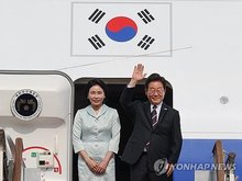 This undated file photo shows President Lee Jae Myung (R) and first lady Kim Hea Kyung in front of the presidential jet. (Yonhap)