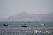 This Reuters file photo shows ships and boats in the Strait of Hormuz in Musandam, Oman, on April 22, 2026. (Yonhap)