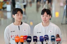 South Korean men's doubles badminton players Kim Won-ho (L) and Seo Seung-jae speak to reporters at Incheon International Airport, west of Seoul, on Aug. 14, 2026, before departing for New Delhi for the Badminton World Federation World Championships. (Yonhap)