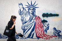 An Iranian woman walks past a mural depicting the Statue of Liberty in ruins in Enghelab Square, central Tehran, on June 14, 2026, in this UPI photo. (Yonhap)
