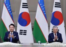 South Korean President Yoon Suk Yeol (L) and Uzbek President Shavkat Mirziyoyev clap during a press briefing after their summit talks at the guesthouse of Kuksaroy Presidential Palace in Tashkent on June 14, 2024. (Yonhap)