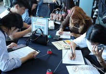 Foreign students write their resumes at a job fair in Busan, about 325 kilometers south of Seoul, on Sept. 27, 2024. (Yonhap)
