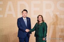 President Yoon Suk Yeol (L) shakes hands with his Peruvian counterpart, Dina Boluarte, ahead of a session of the Asia-Pacific Economic Cooperation (APEC) summit on Nov. 16, 2024. (Pool photo) (Yonhap)