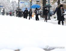 People walk outside amid heavy snow in Seoul on Nov. 28, 2024. (Yonhap)