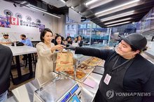 First lady Kim Hea Kyung (L) buys food at a store in Koreatown in New York on Sept. 23, 2025. (Pool photo) (Yonhap)
