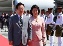 President Lee Jae Myung (L) and first lady Kim Hea Kyung walk on the red carpet upon their arrival at Kuala Lumpur International Airport in Kuala Lumpur, Malaysia, on Oct. 26, 2025, to attend the Association of Southeast Asian Nations summit. (Yonhap)