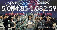 People are seen cheering inside the dealing room in Woori Bank of central Seoul after the benchmark Korea Composite Stock Price Index (KOSPI) surpassed the landmark 5,000 points, in this photo taken Jan. 27, 2026. (Yonhap)