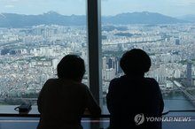 Visitors to Lotte World Tower in southern Seoul view apartment complexes on Aug. 13, 2026. (Yonhap)