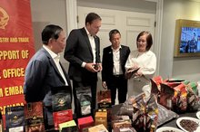 Trade Counsellor Tran Thu Quynh (first, right) introduces high-quality coffee products of Vietnam to Chairman of the Coffee Association of Canada Robert Carter (second from the left). (Photo: VNA)