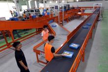 Employees of online shopping platform Lazada are classifying parcels. (Photo: VNA)