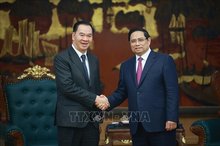 Prime Minister Pham Minh Chinh (R) receives Lao Minister of Education and Sports Thongsalith Mangnormek in Hanoi on December 16 (Photo: VNA)