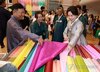 Kim Hea Kyung (R), wife of President Lee Jae Myung, looks at fabric used to make "hanbok," traditional Korean attire, during Hanbok Expo, an industry fair on the Korean dress, in Seoul on Aug. 14, 2026. (Yonhap) (END)