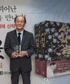 Renowned novelist Jo Jung-rae poses for a photo with a copy of his new novel, "Seorikkot" (Frost Flower), during a press conference in Seoul on Aug. 24, 2026, to mark the publication of the novel. (Yonhap) (END)