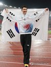 Woo Sang-hyeok of South Korea holds the South Korean flag after winning the bronze medal in the men's high jump final at the Aichi-Nagoya Asian Games at Nagoya City Mizuho Park Athletic Stadium in Nagoya, central Japan, on Sept. 27, 2026. (Yonhap) (END)