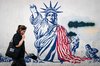 An Iranian woman walks past a mural depicting the Statue of Liberty in ruins in Enghelab Square, central Tehran, on June 14, 2026, in this UPI photo. (Yonhap)