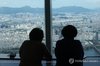 Visitors to Lotte World Tower in southern Seoul view apartment complexes on Aug. 13, 2026. (Yonhap)