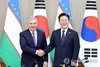 South Korean President Lee Jae Myung (R) and Uzbek President Shavkat Mirziyoyev shake hands during their summit talks in Seoul on Sept. 14, 2026. (Yonhap)