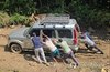 Members of the second contingent of South Korea's Korea Disaster Relief Team (KDRT) push a vehicle stuck in mud while traveling to a village in Nepal on Sept. 14, 2026. (Yonhap)