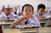 File photo - Students eat free nutritious meals provided by the government at a public elementary school in Palembang.
